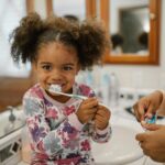 child brushing her teeth